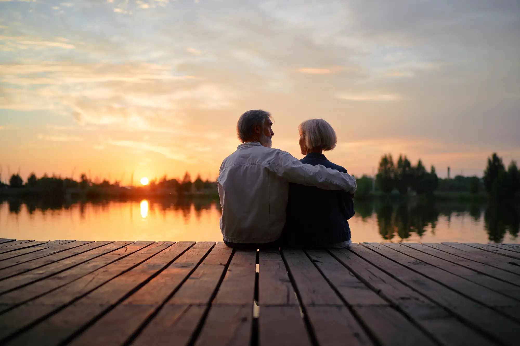 Older couple sitting and watching sunset