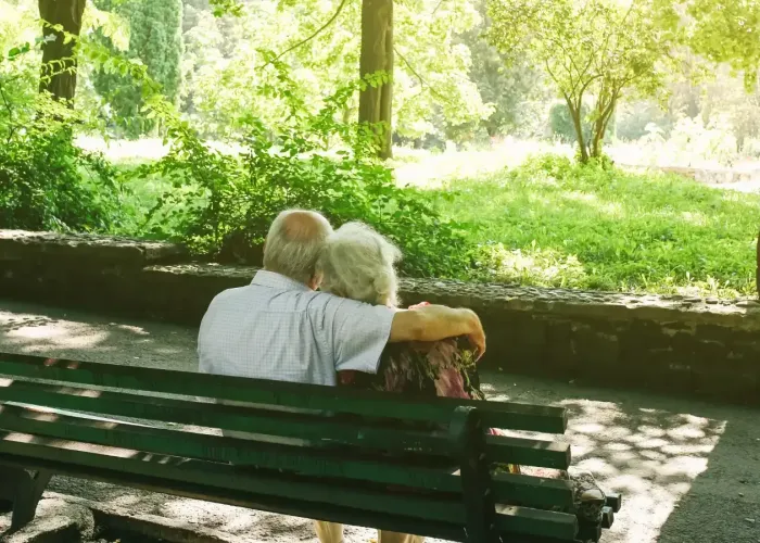 Older couple sitting on park bench